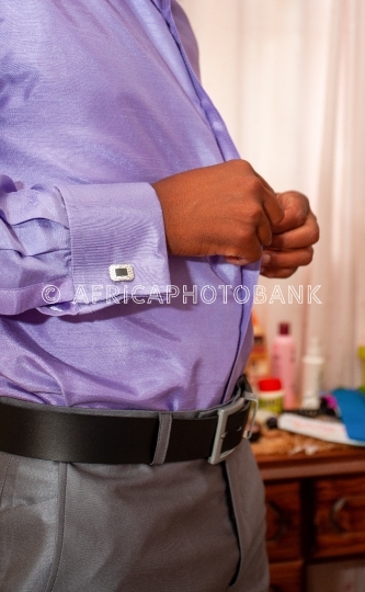 man buttoning shirt