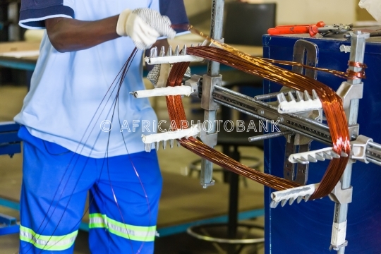 African man rewinding electric motor
