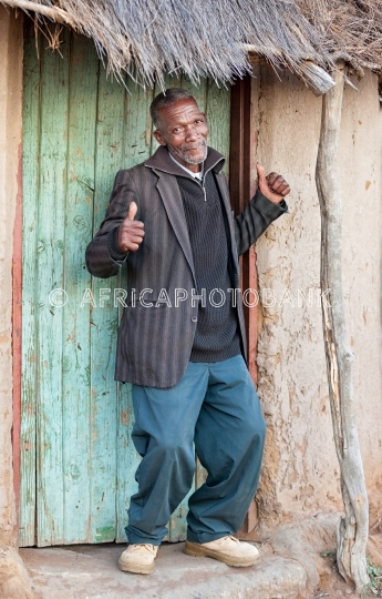 Happy senior in front of a shack