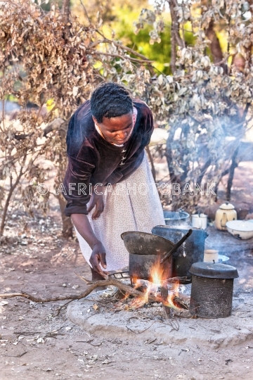 African woman cooking in the summer kitchen