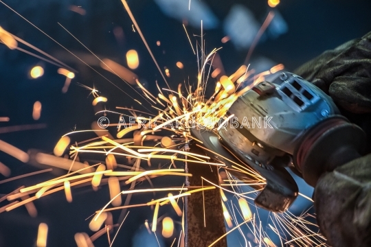 African man grinding metal