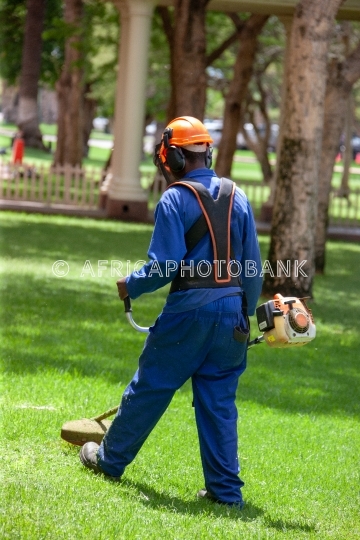 African man cutting grass